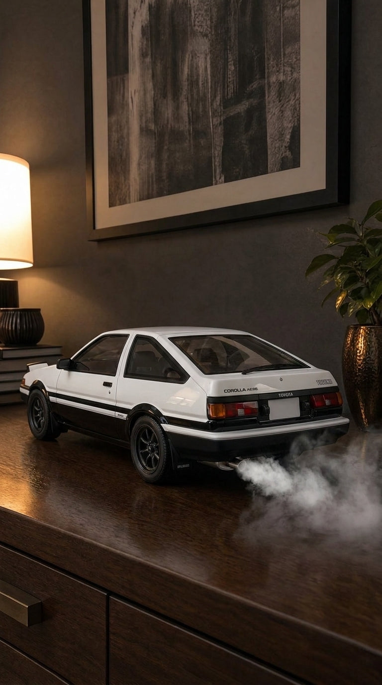 White and black panda Toyota Corolla AE86 model with black six-spoke wheels, smoke from the exhaust