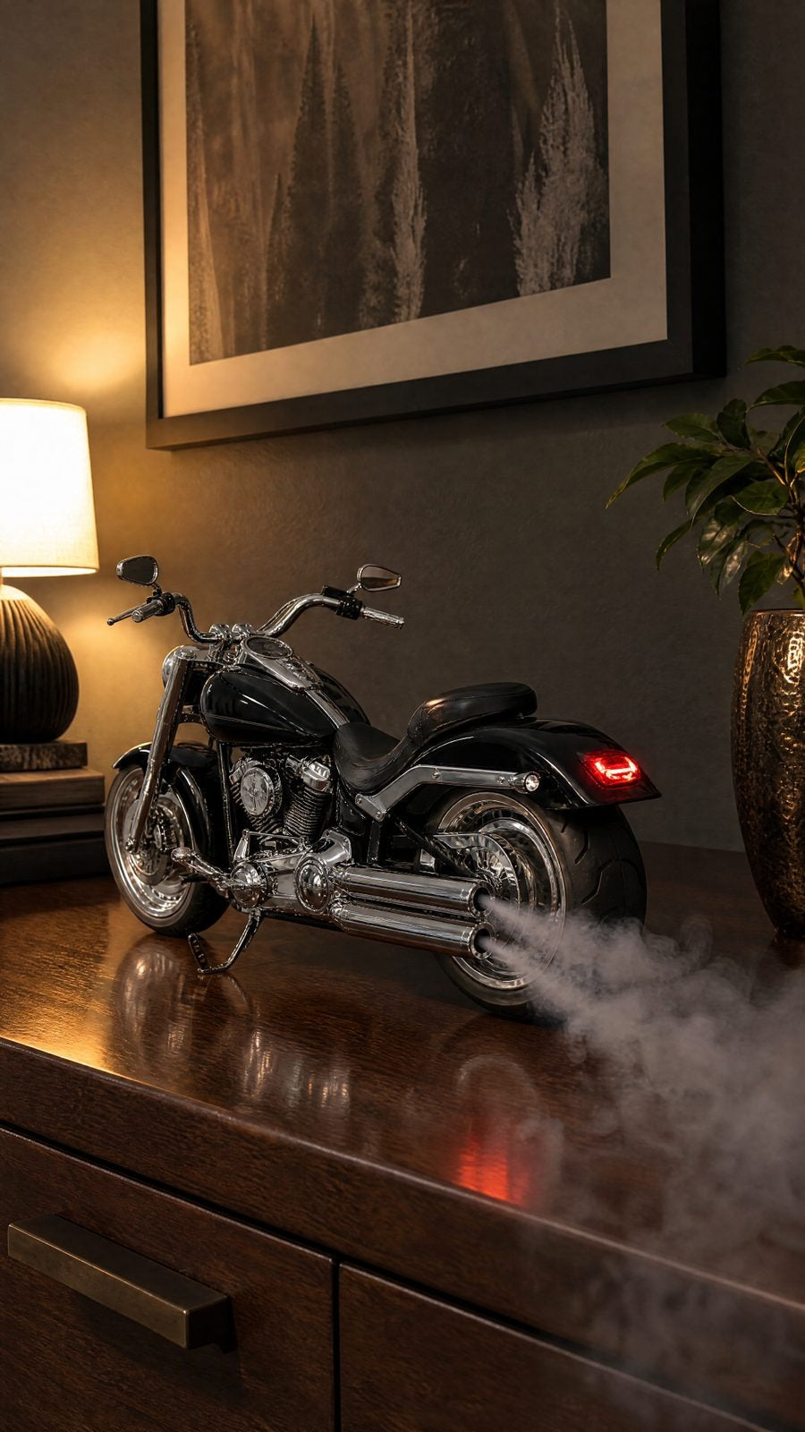 Black and chrome cruiser motorcycle model on a dark wood dresser, smoke from twin chrome exhausts, red tail light on