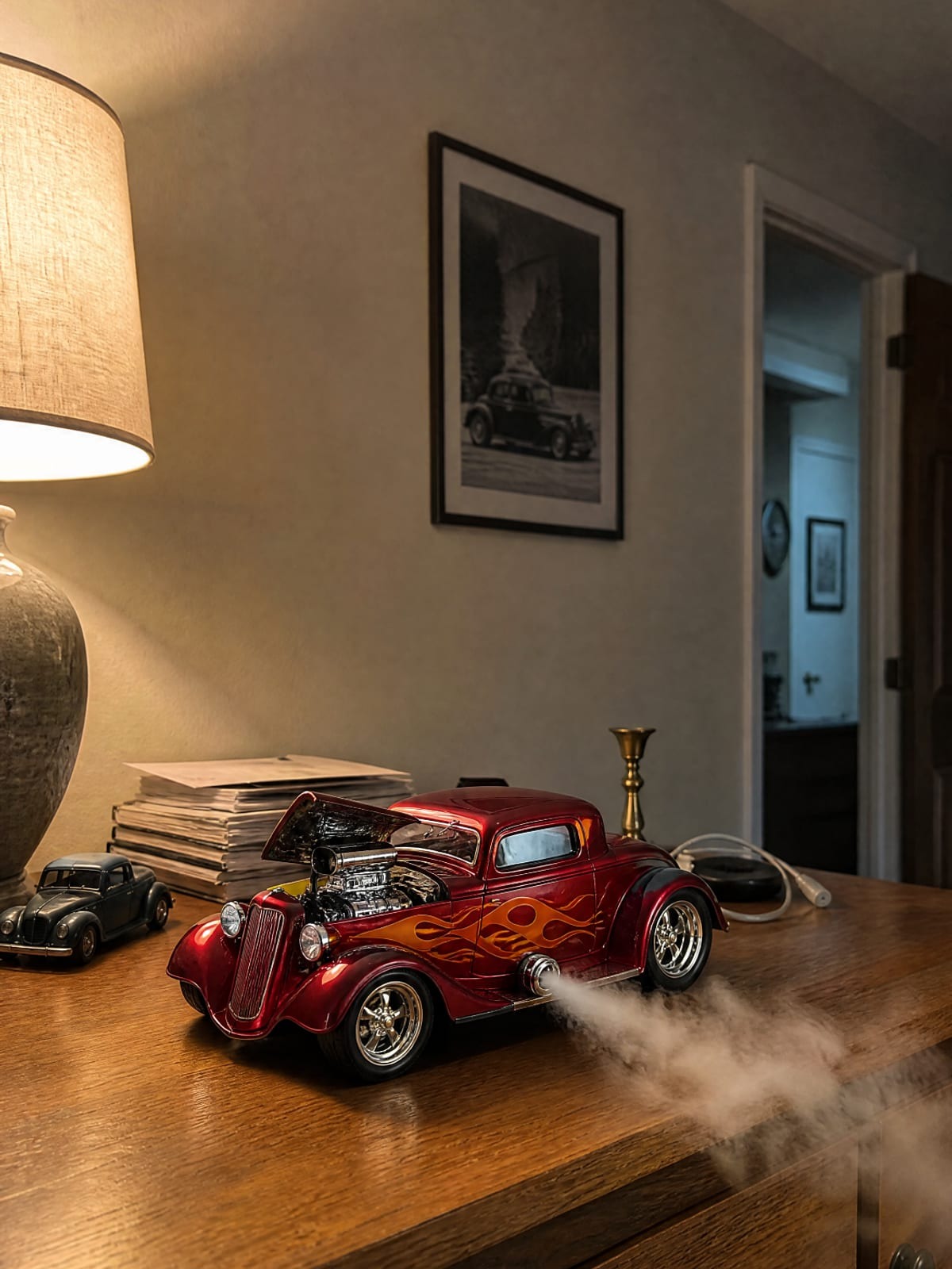 Candy red hot rod coupe model with orange flames and chrome supercharged engine, smoke from the side pipe